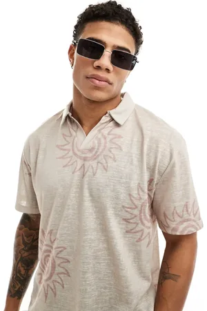 ASOS Relaxed polo shirt in beige with multi sun prints